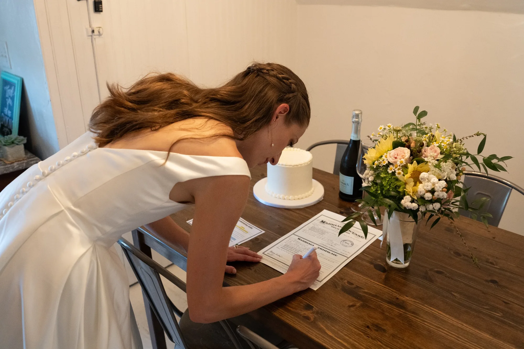 Isabella signing the marriage certificate at the Airbnb after her Colorado horseback elopement