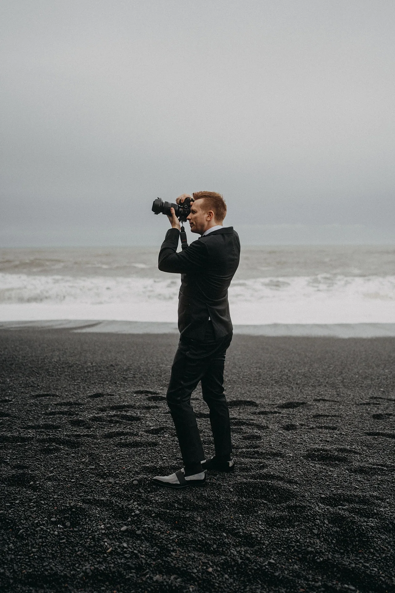 Eric Lucky photographing his wife on Reynisfjara Black Sand Beach in Iceland